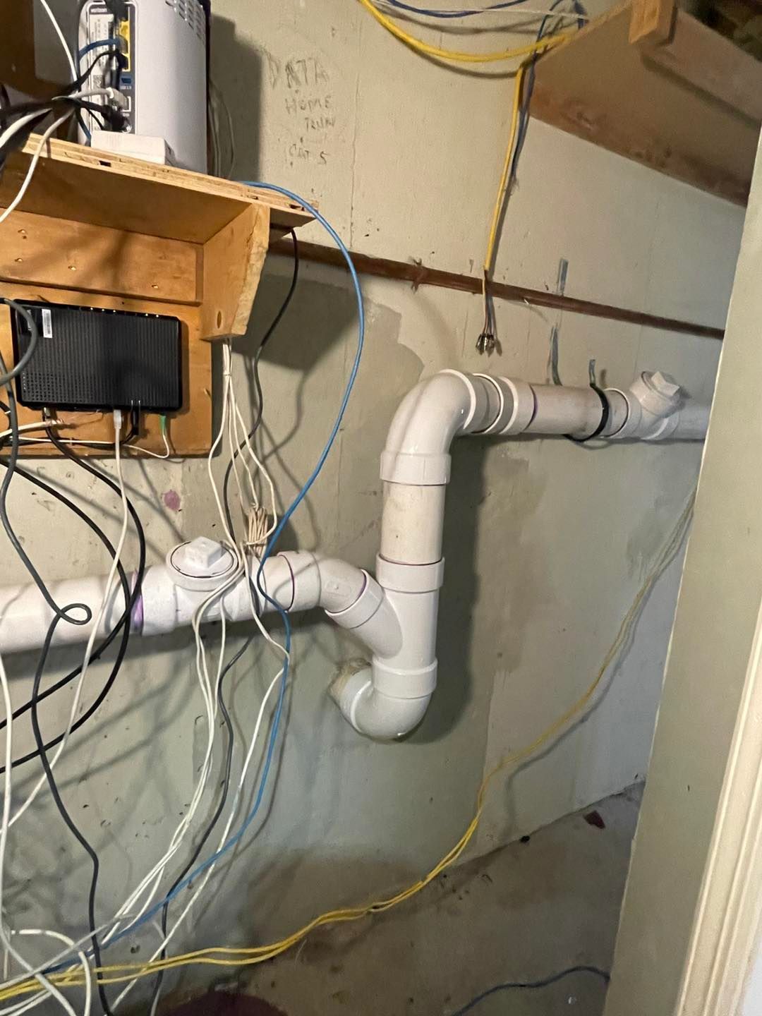 A bunch of wires are connected to a pipe in a room.