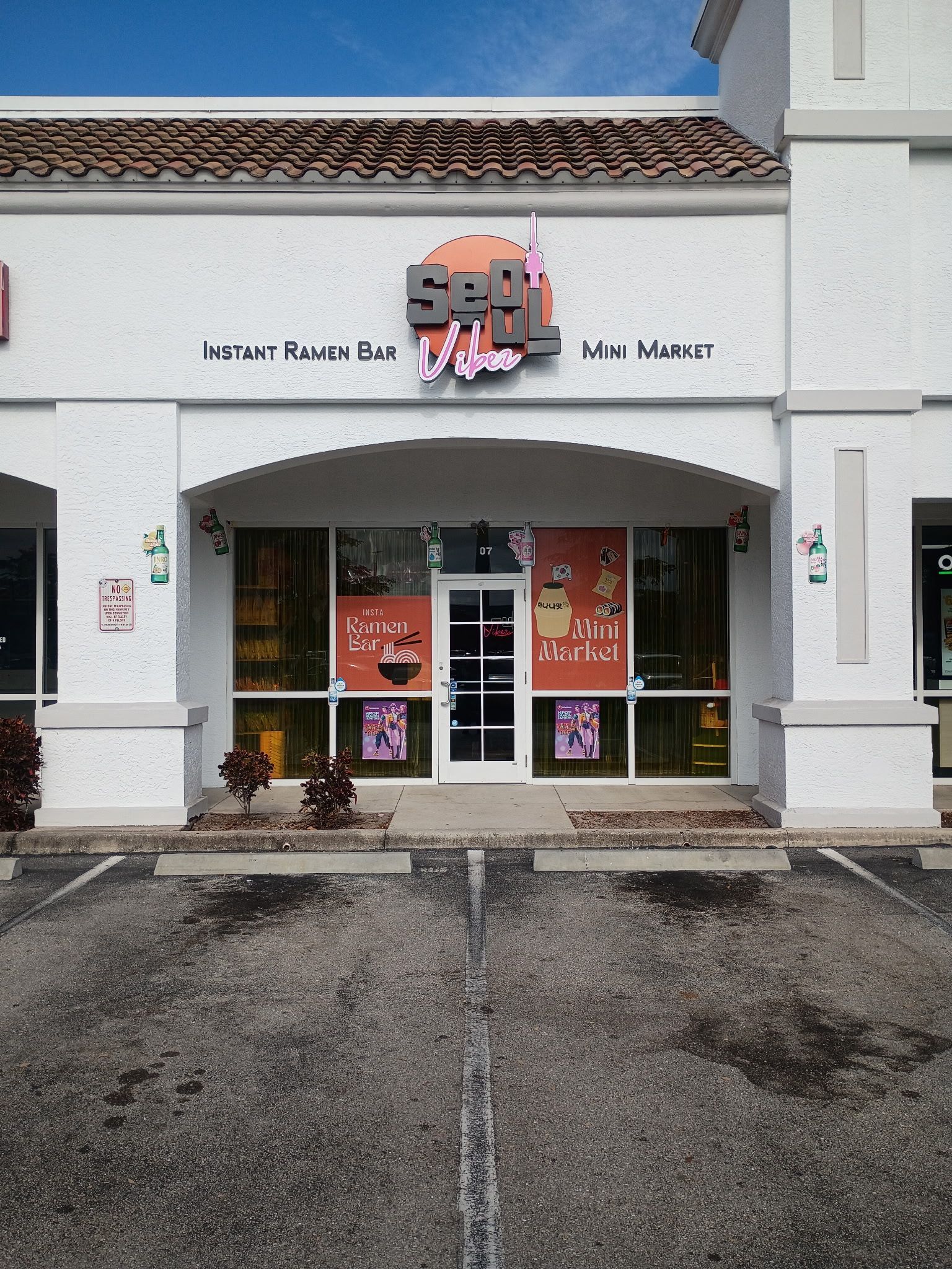A storefront for Seoul Korean restaurant, featuring a white exterior, glass doors, and parking spaces in front.