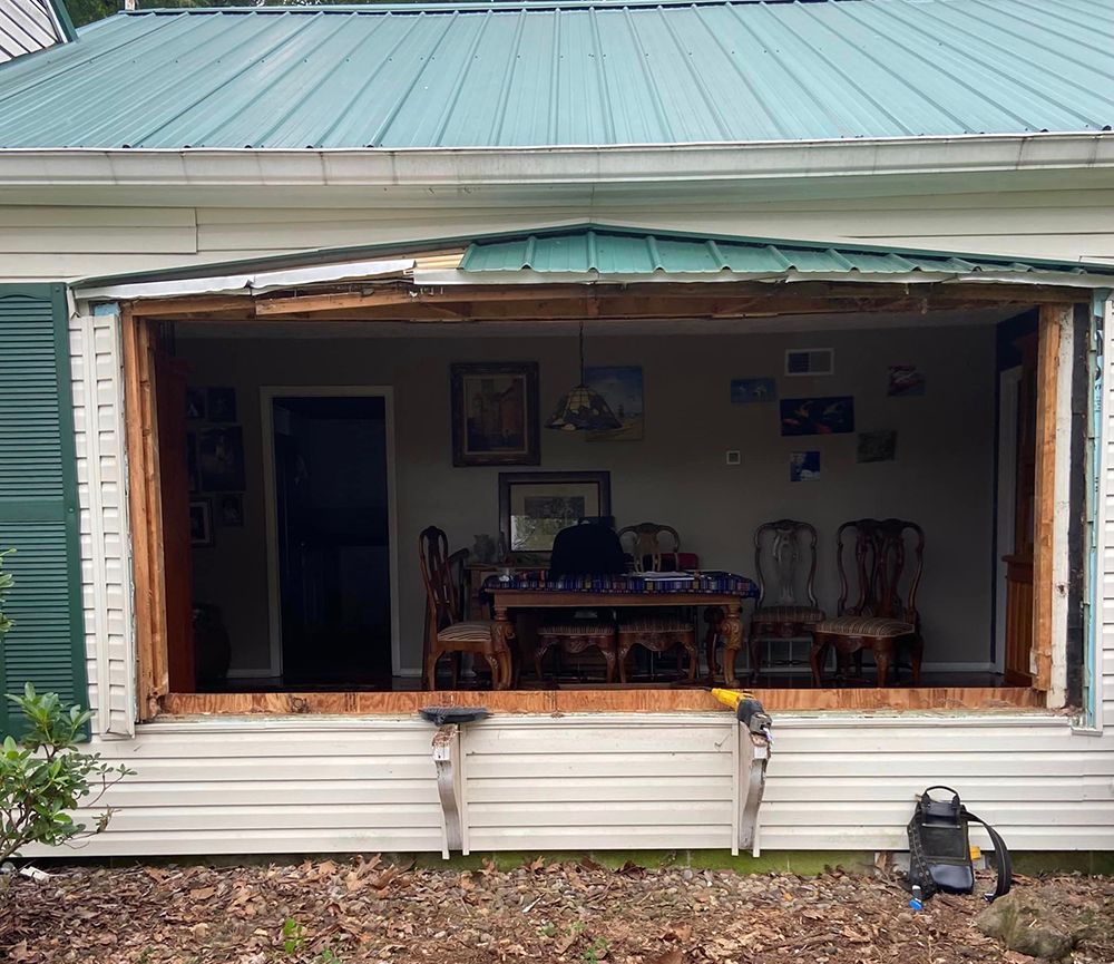 A house with a green roof and a dining room with a table and chairs