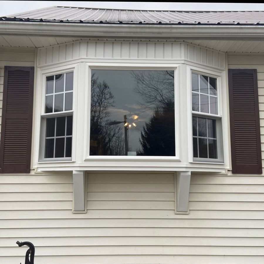 A house with a bay window and brown shutters