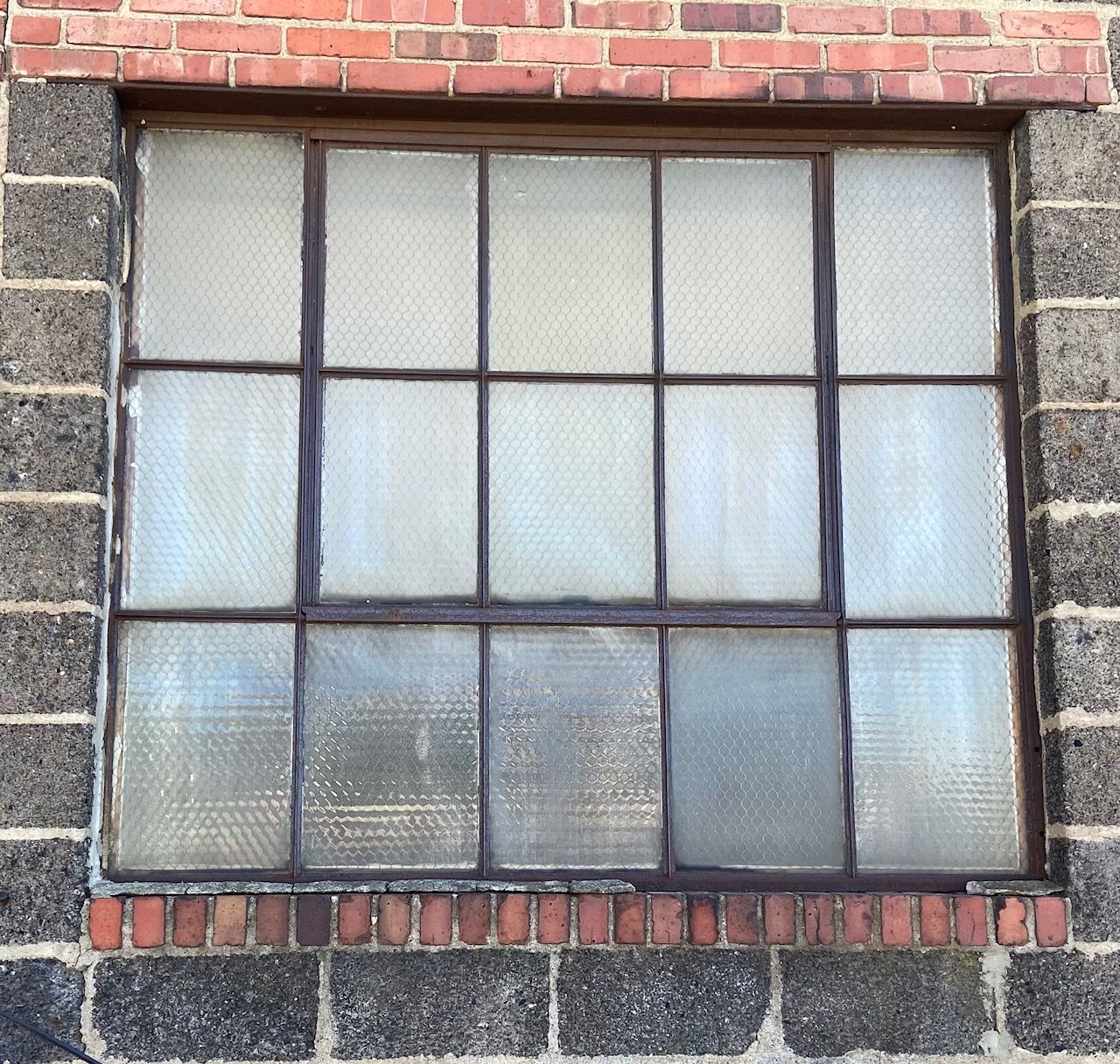 A window on a brick building with a metal frame