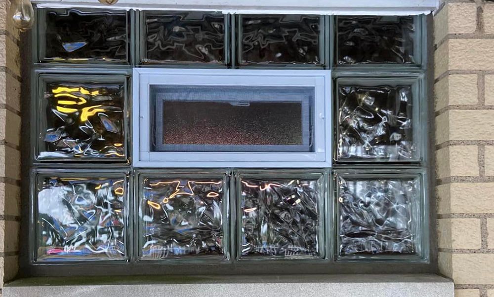 A window made of glass blocks on a brick wall