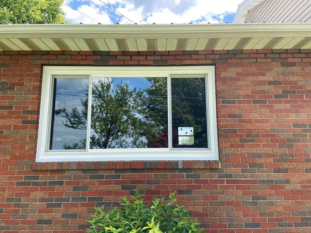 A brick house with a large window on the side of it.