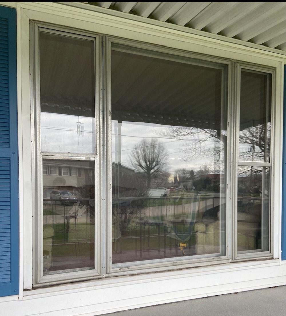 A porch with a large window and blue shutters