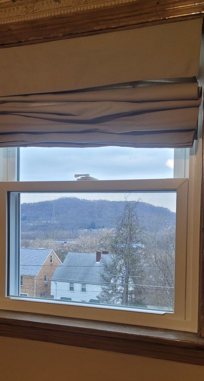 A window with a view of a city and mountains.
