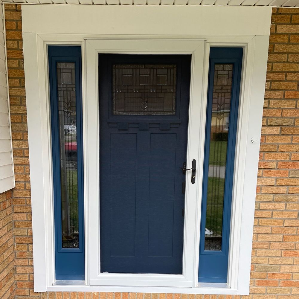 A blue door with white trim is on a brick building
