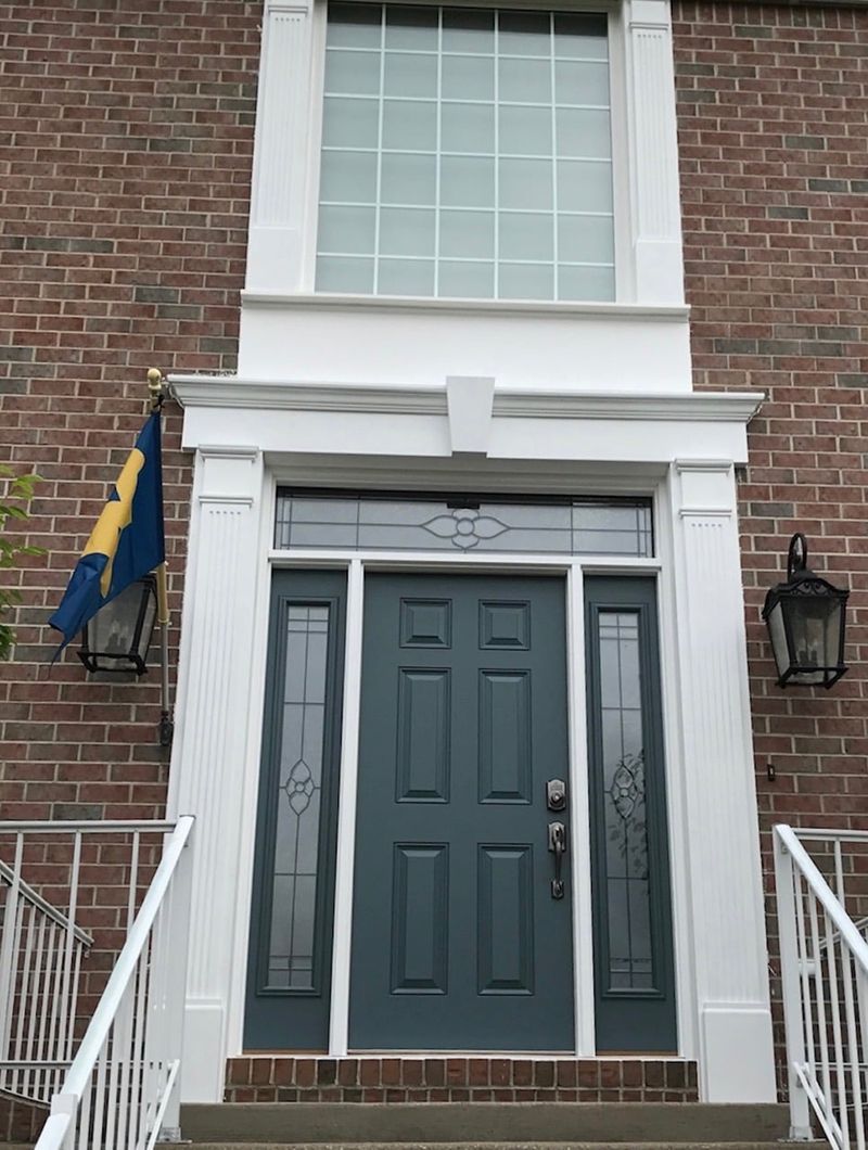 A brick house with a blue door and stairs