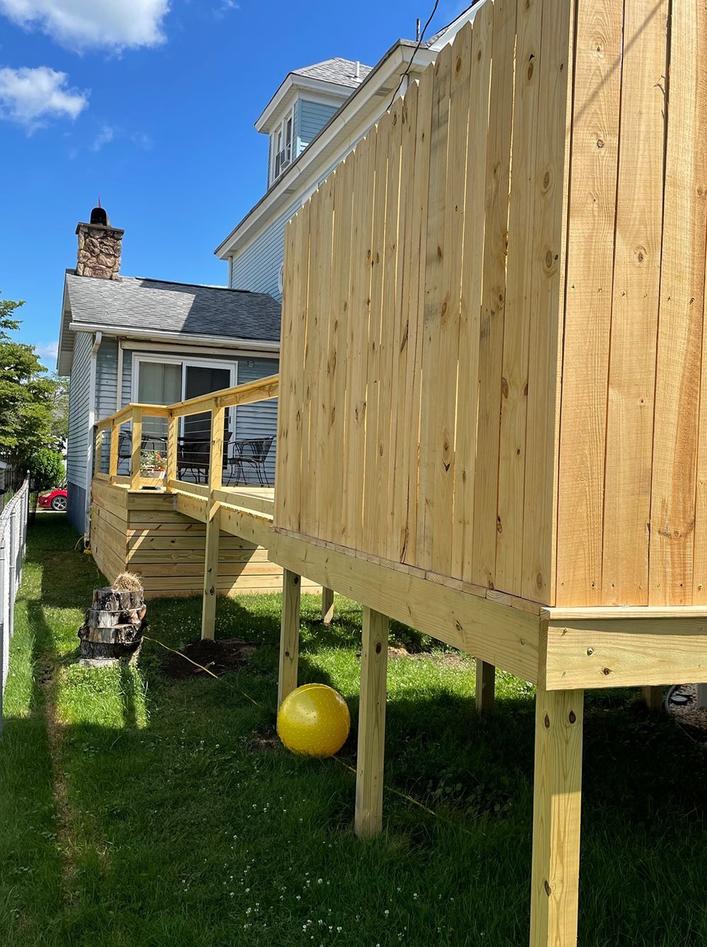 A wooden deck is being built in the backyard of a house.