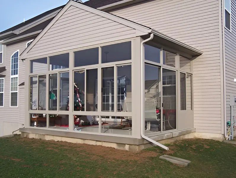 A house with a screened in porch with lots of windows