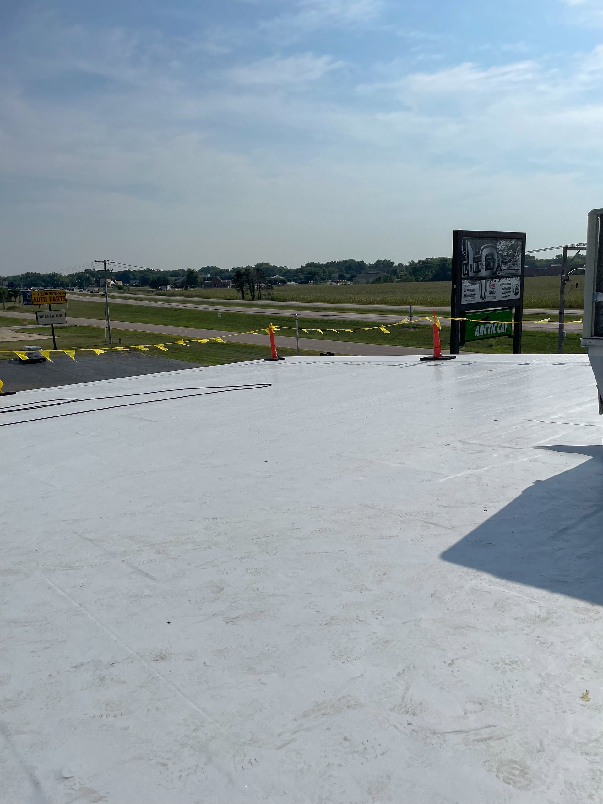 Concrete terrace overlooking a grassy airfield under a cloudy sky