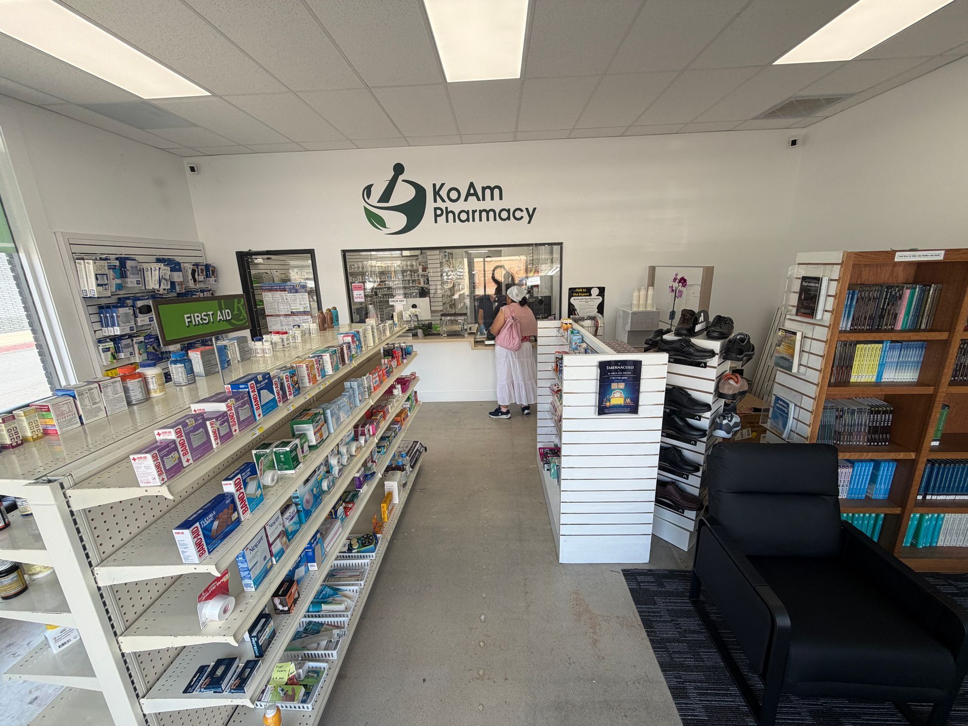 Bright optical store interior with glasses displays, black chairs, and a person near the counter