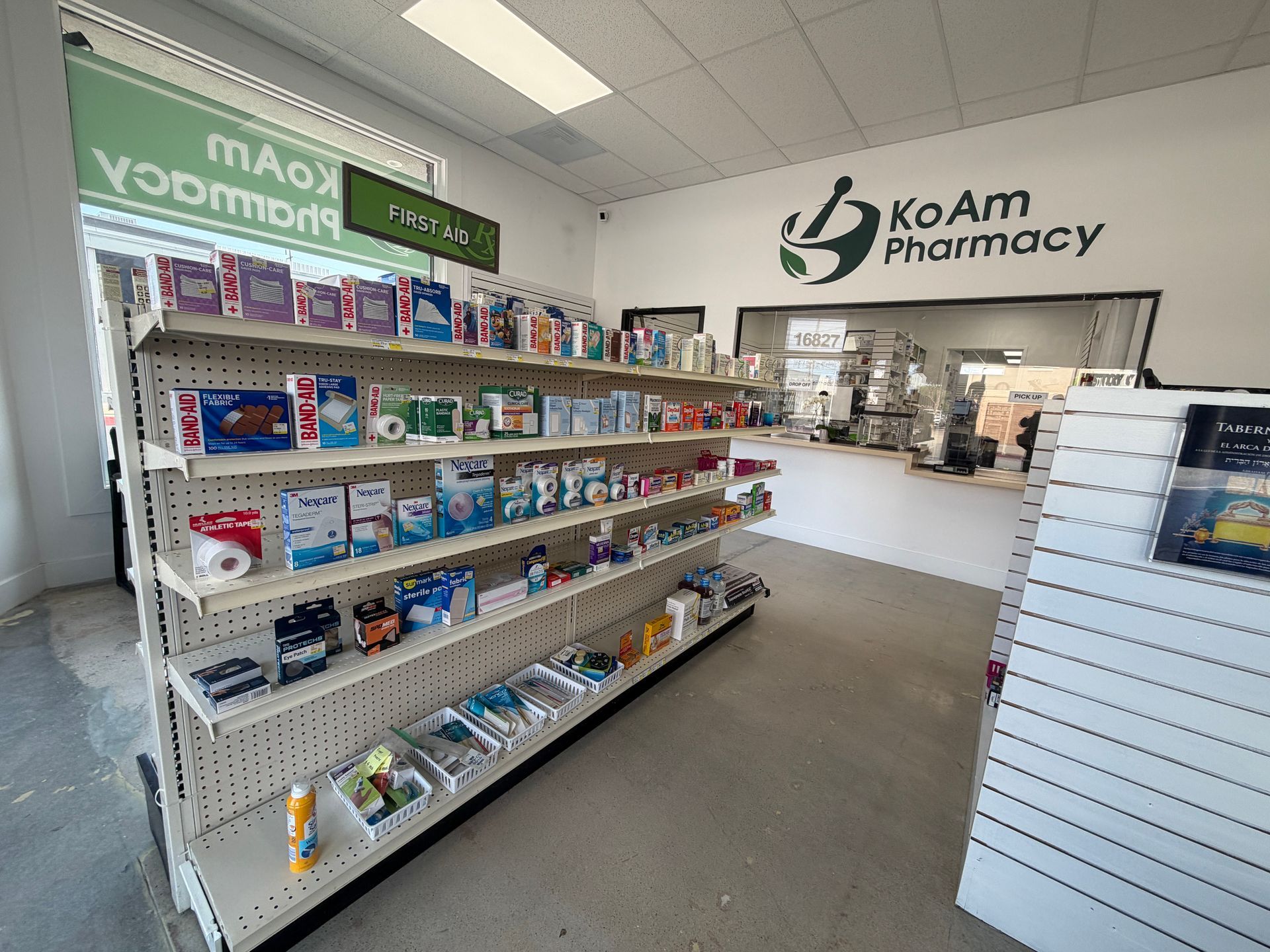 KOAM Pharmacy interior with retail shelves stocked with medicines and a service counter