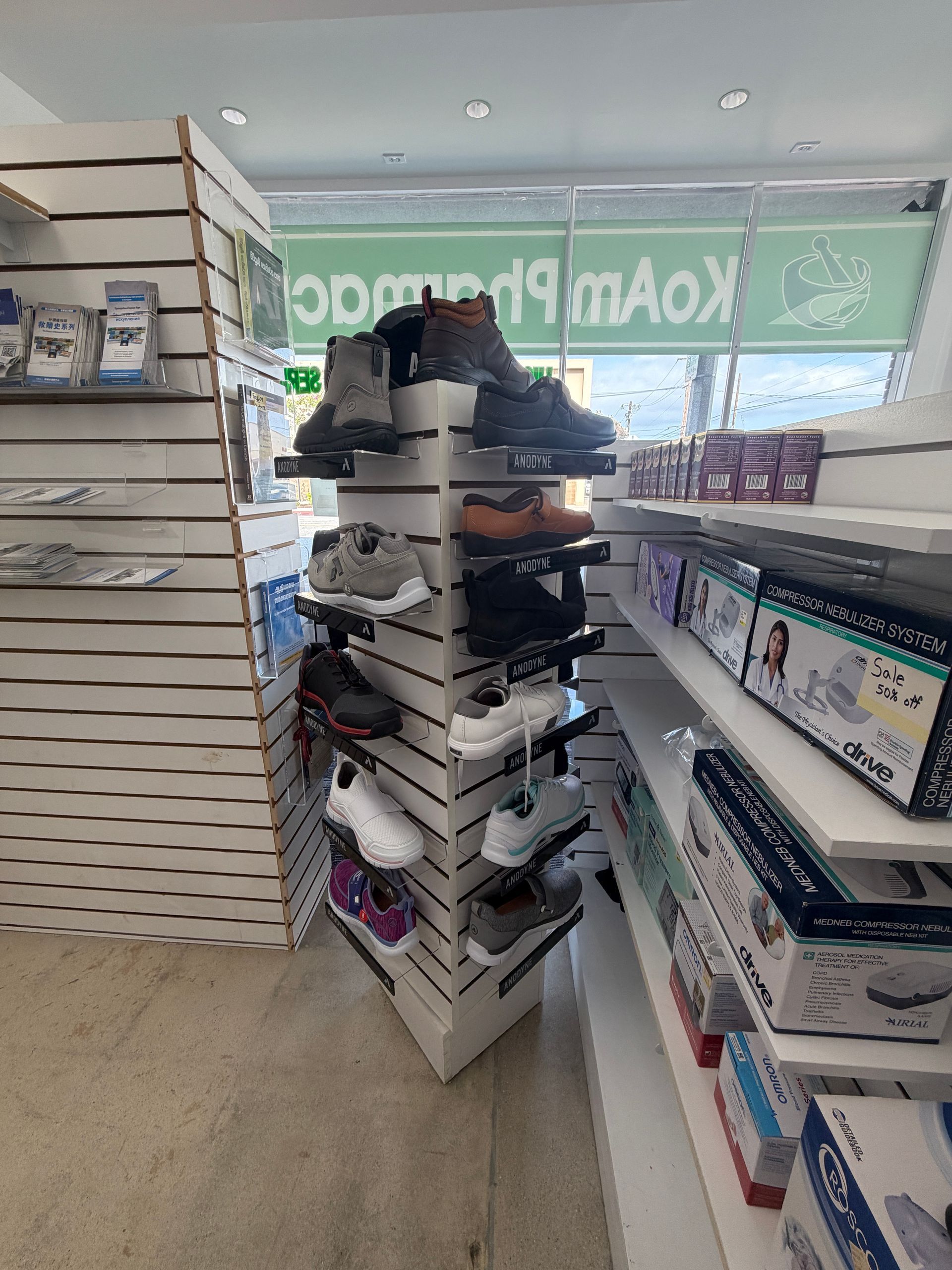 Shoe store aisle with stacked boxes and shelves of shoes under bright store lighting.