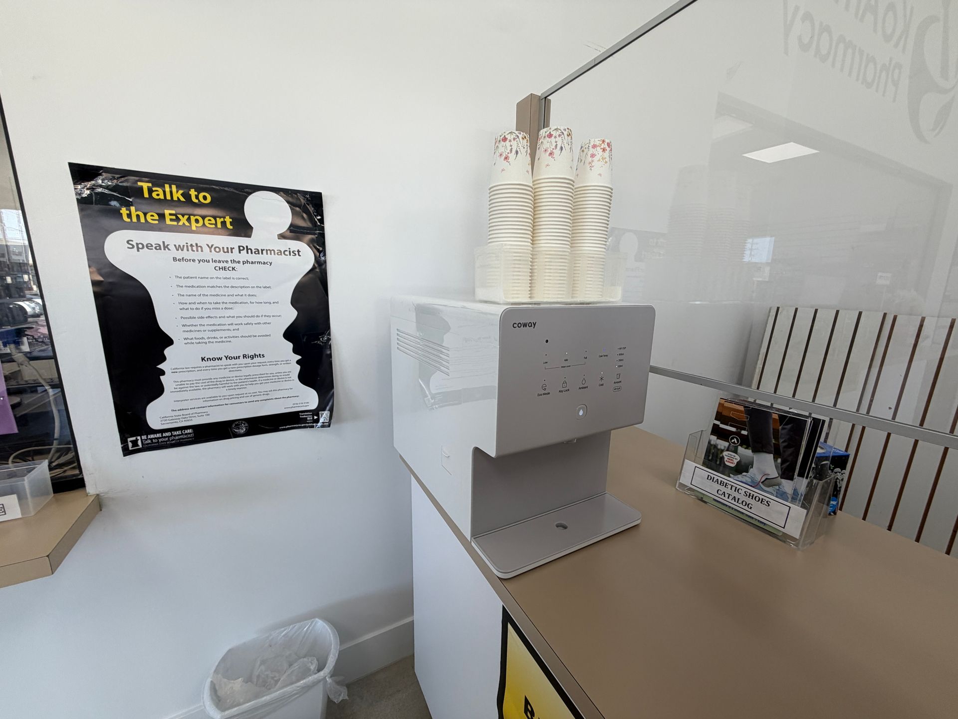 Office counter with a white dispenser and cups beside a “Talk to the Boss” sign on the wall
