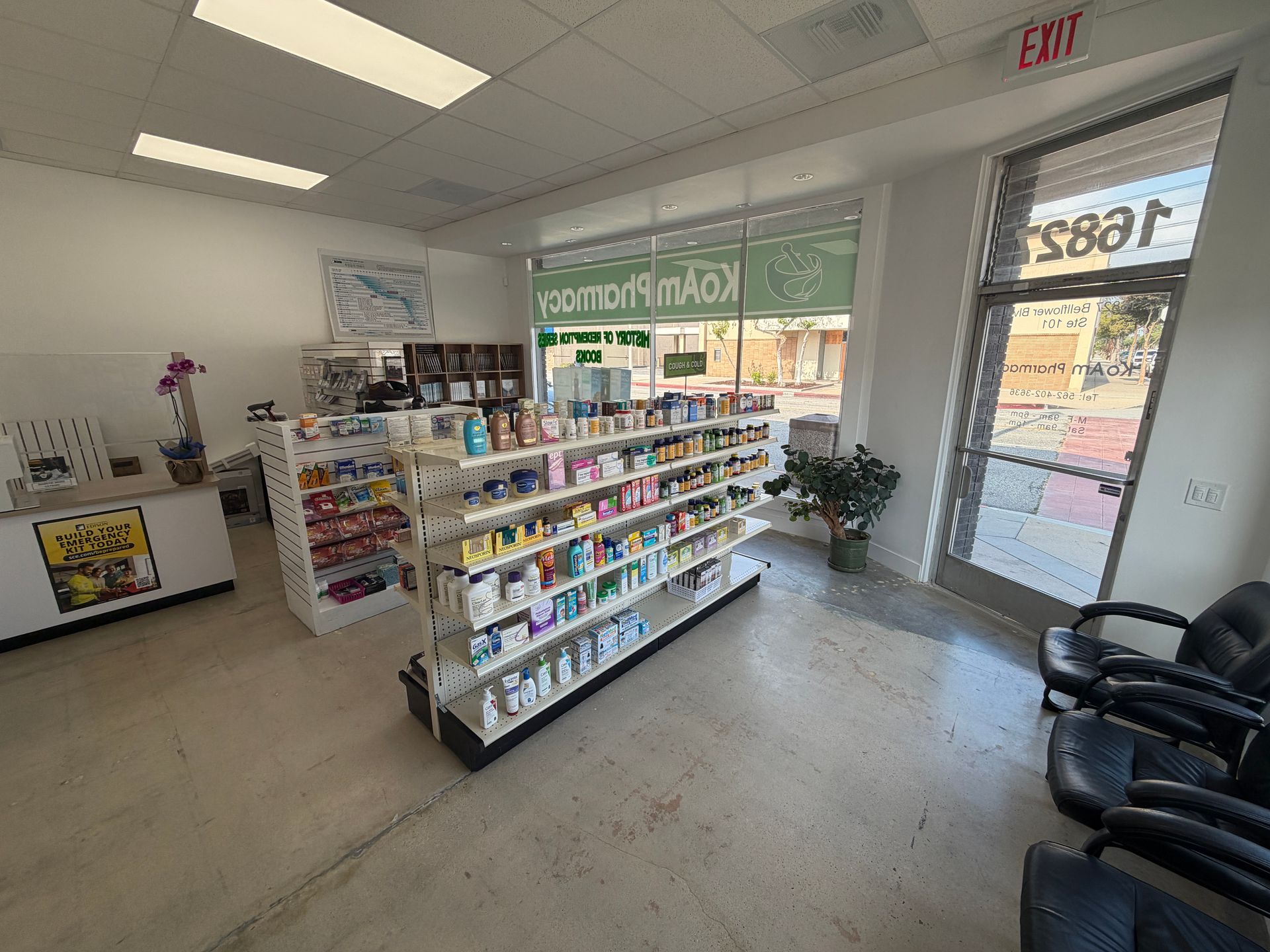 Bright lobby with brochure racks, seating, and a glass door entrance to a storefront.