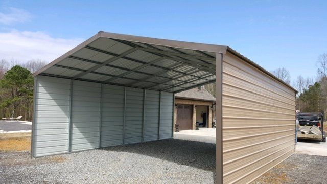 Metal carport with brown roof and tan walls, on a gravel surface under a clear, blue sky.
