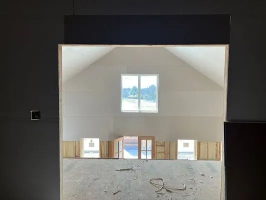 Interior view through a doorway showing windows in a building under construction.