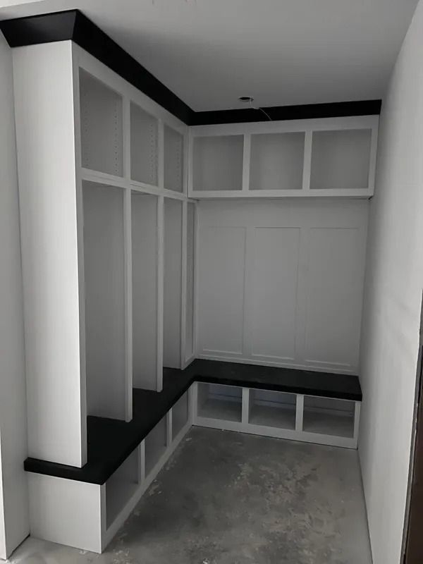 Built-in white and black mudroom storage with cubbies, lockers, and a bench.
