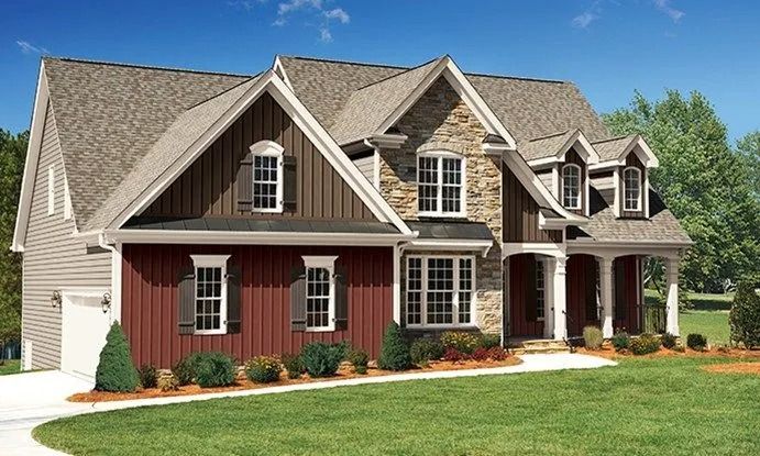 Two-story house with brown siding, stone accents, and a covered porch, on a green lawn.