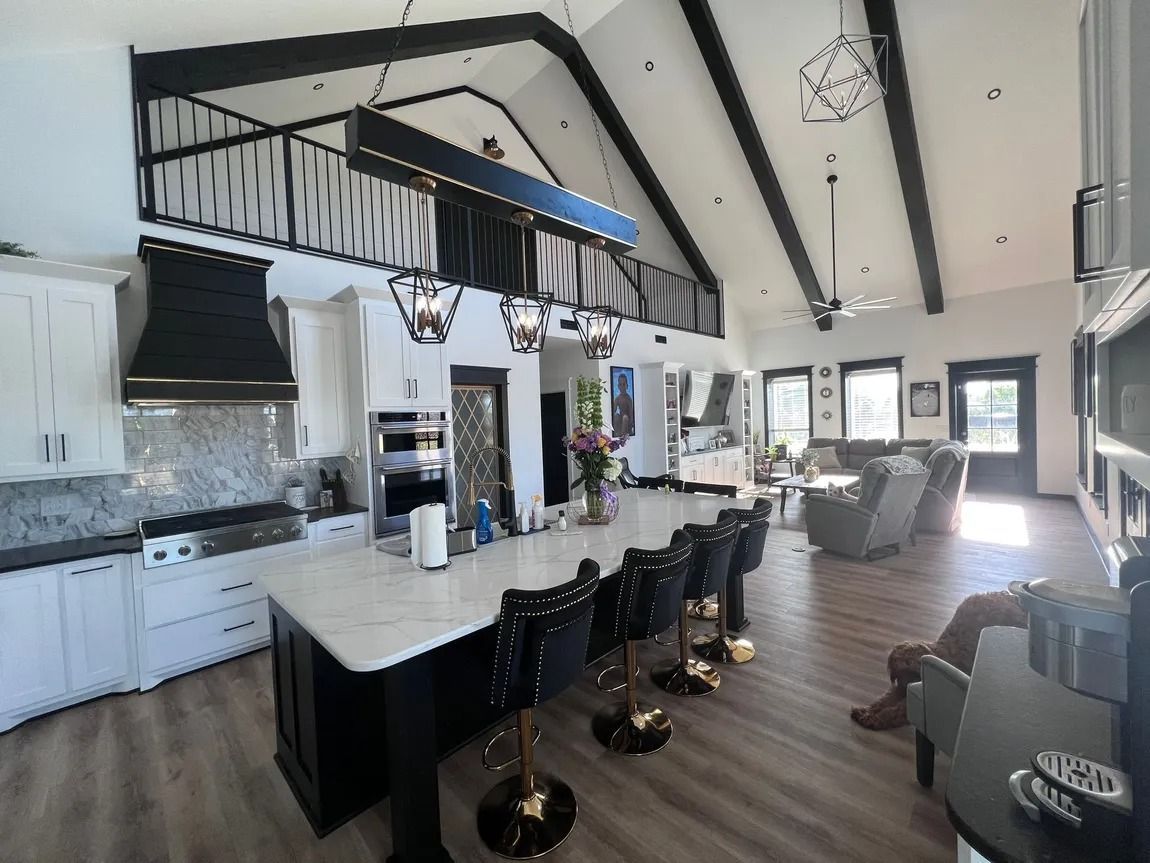 Spacious modern kitchen with island, black accents, and vaulted ceiling.
