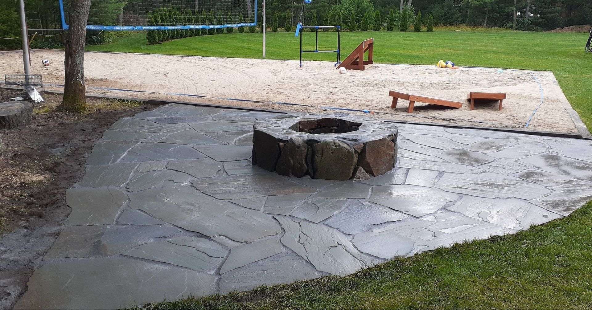 A fire pit is sitting in the middle of a concrete patio.