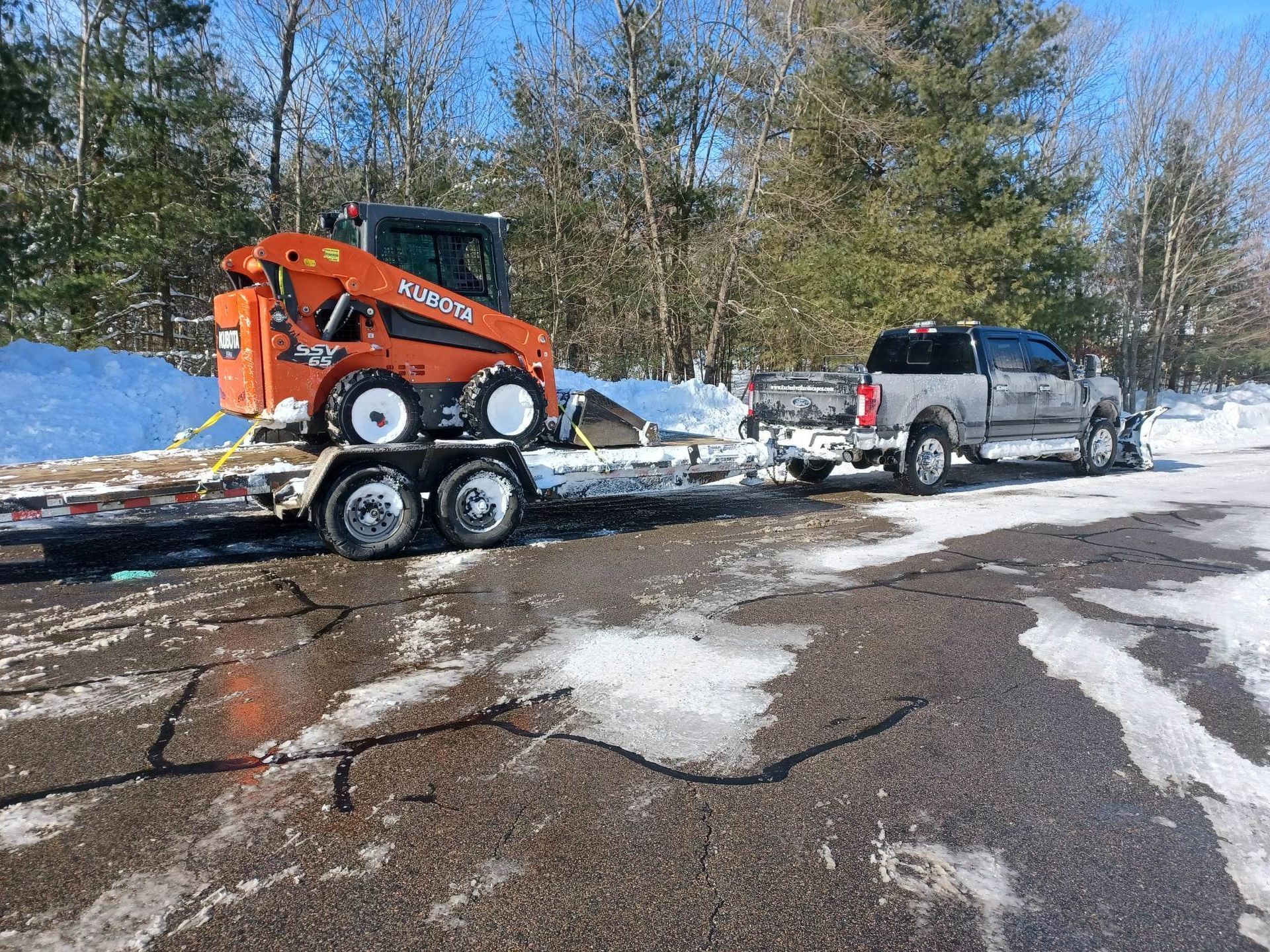 A truck is towing a trailer with a bulldozer on it.