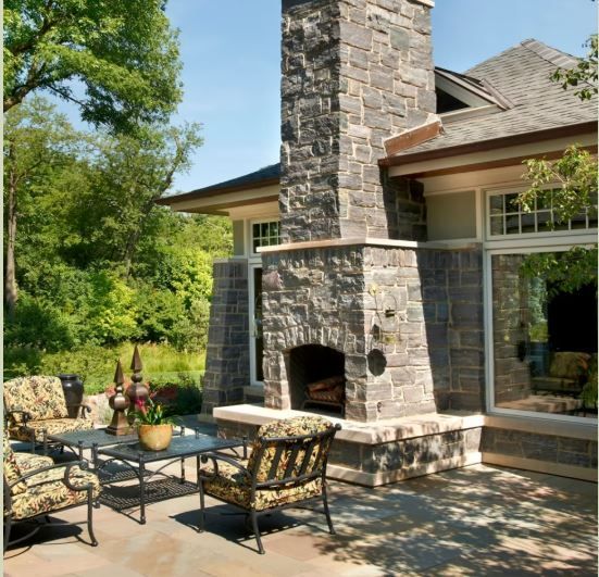 A house with a stone fireplace and patio furniture