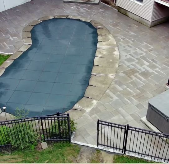 A large swimming pool with a black fence around it
