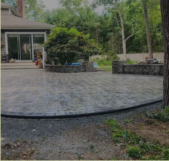 A patio in front of a house with trees in the background.