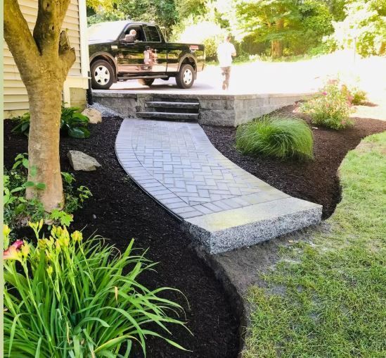 A truck is parked on the side of the road next to a walkway.