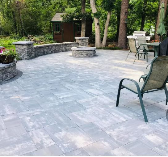 A patio with a fire pit and a table and chairs