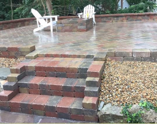 A brick patio with stairs and chairs on it