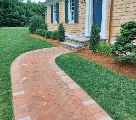 A brick walkway leading to the front door of a house.