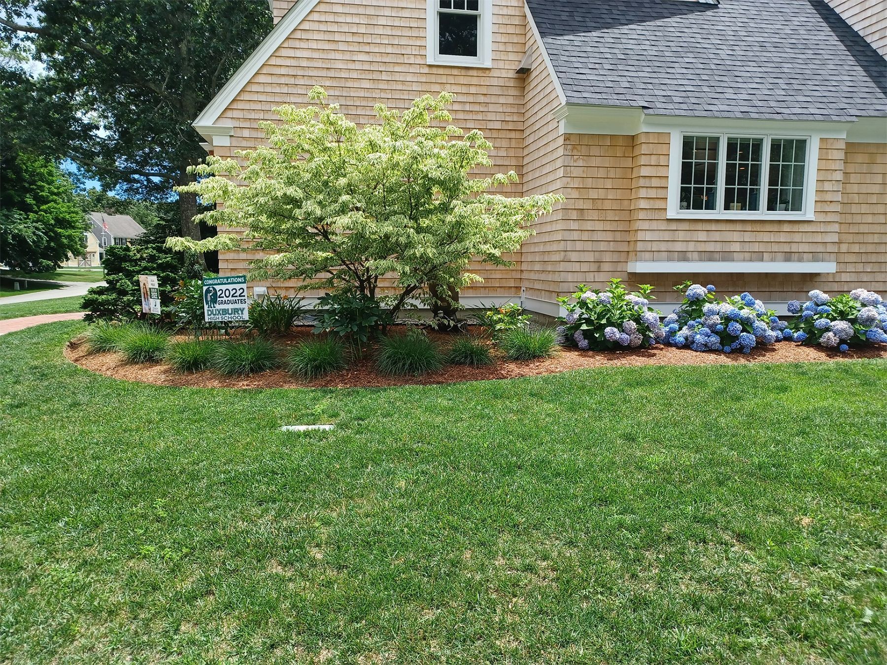 A house with a lush green lawn in front of it.