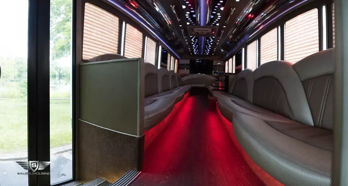 Interior view of a limousine with beige seating and red under-lighting.