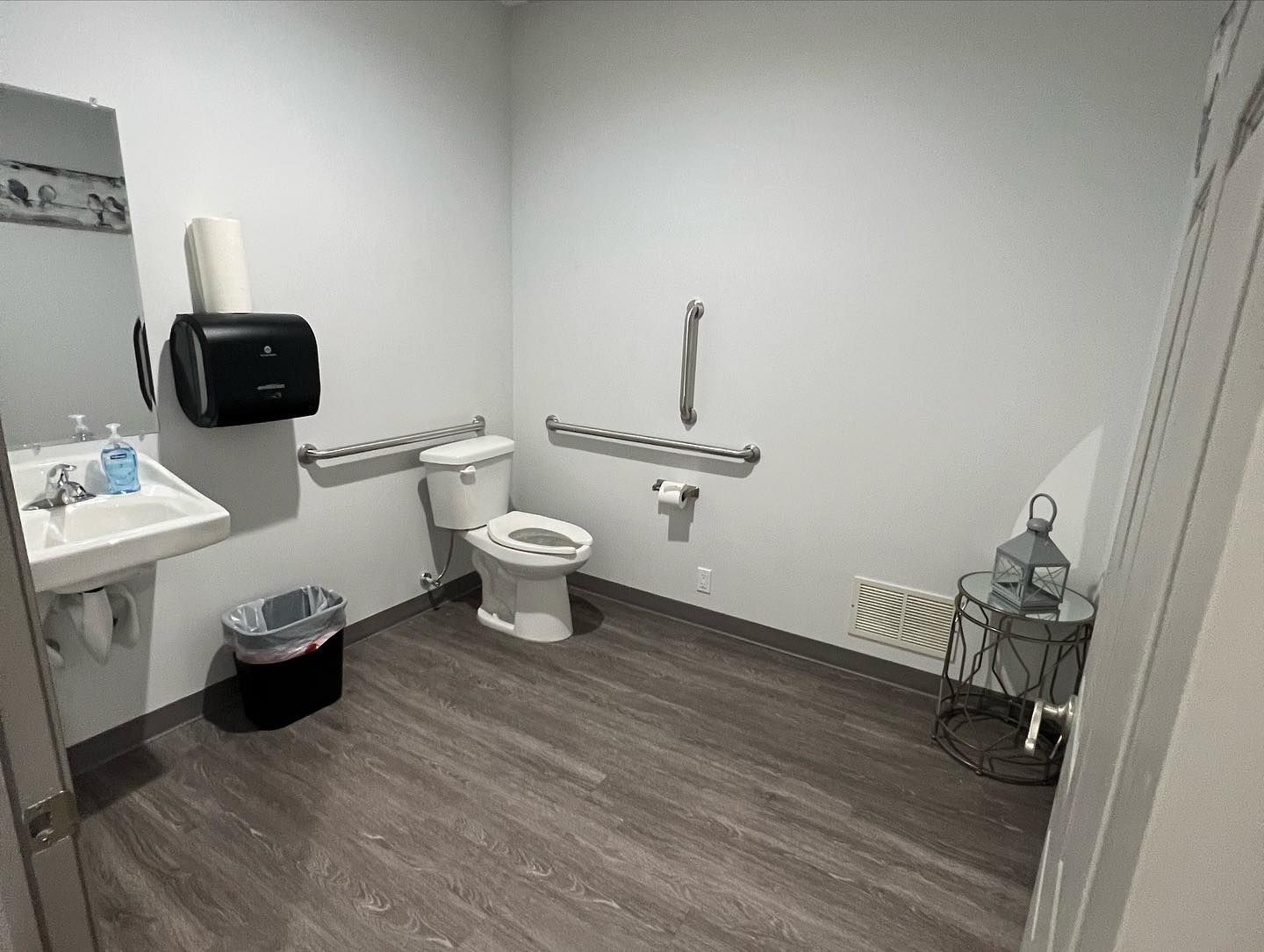 A bathroom with a toilet , sink and mirror.