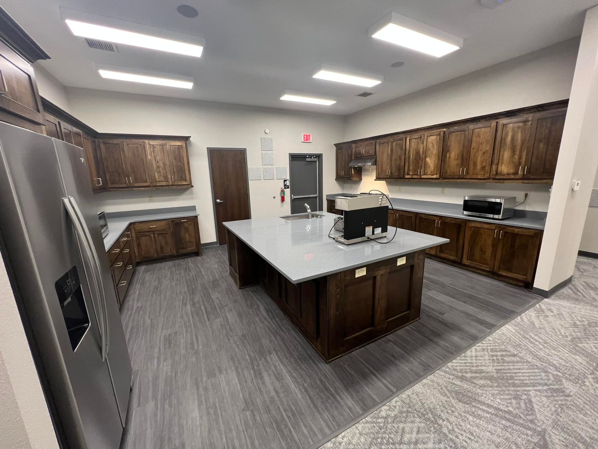 A large kitchen with stainless steel appliances and wooden cabinets.