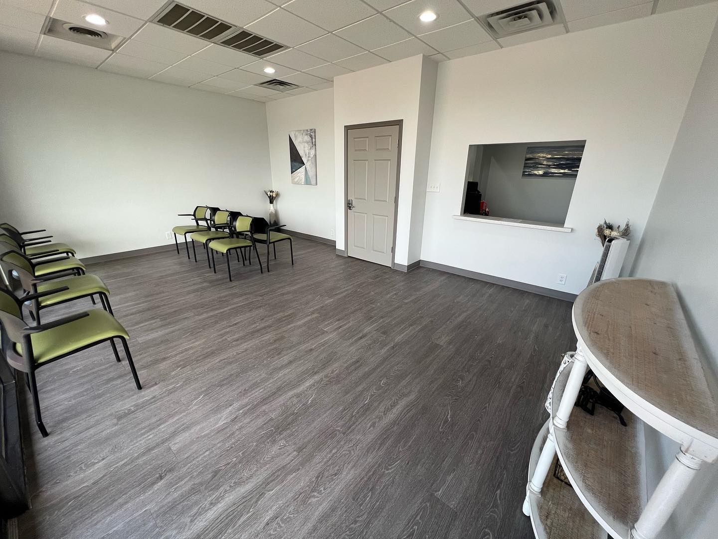 A waiting room with chairs and a cat tree.