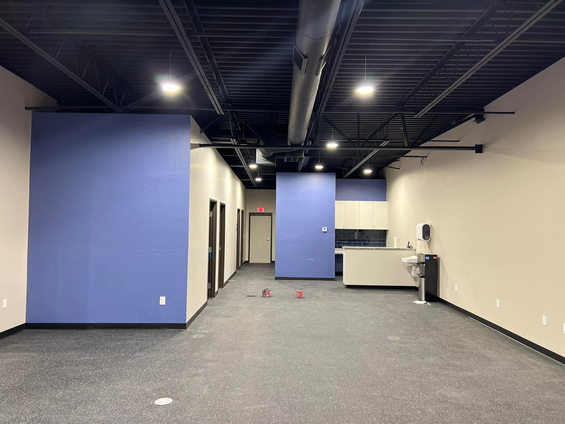 A large empty room with blue walls and a black ceiling.