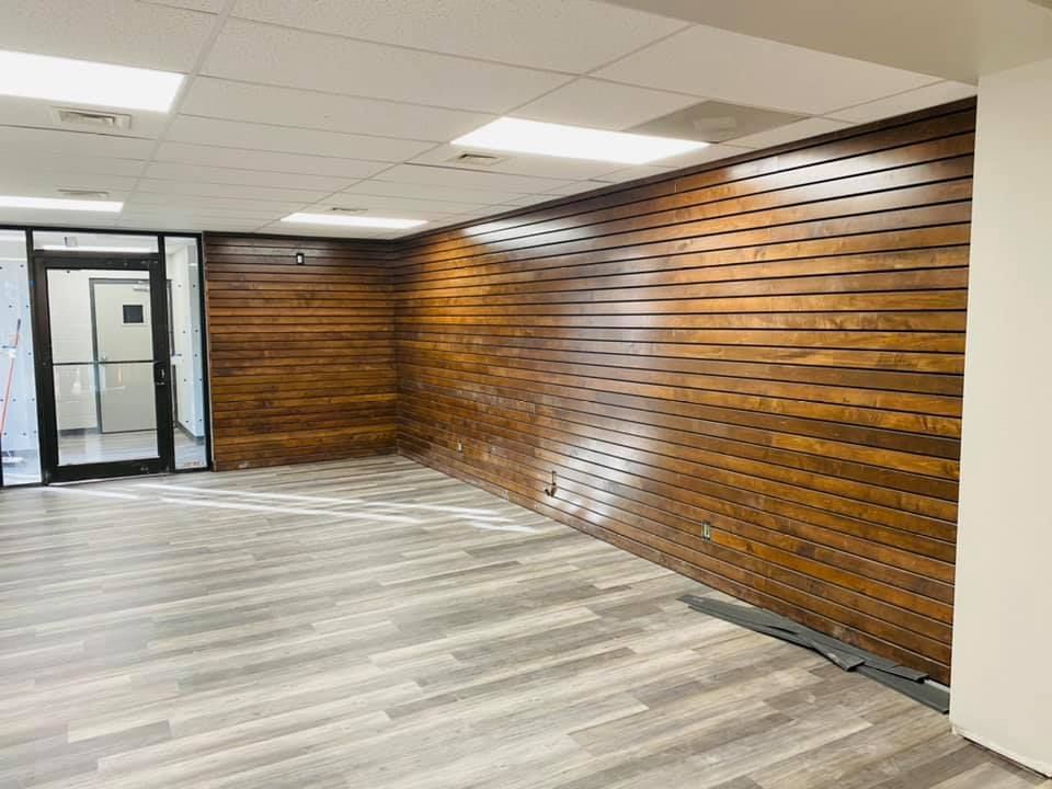 An empty room with wooden walls and a glass door.