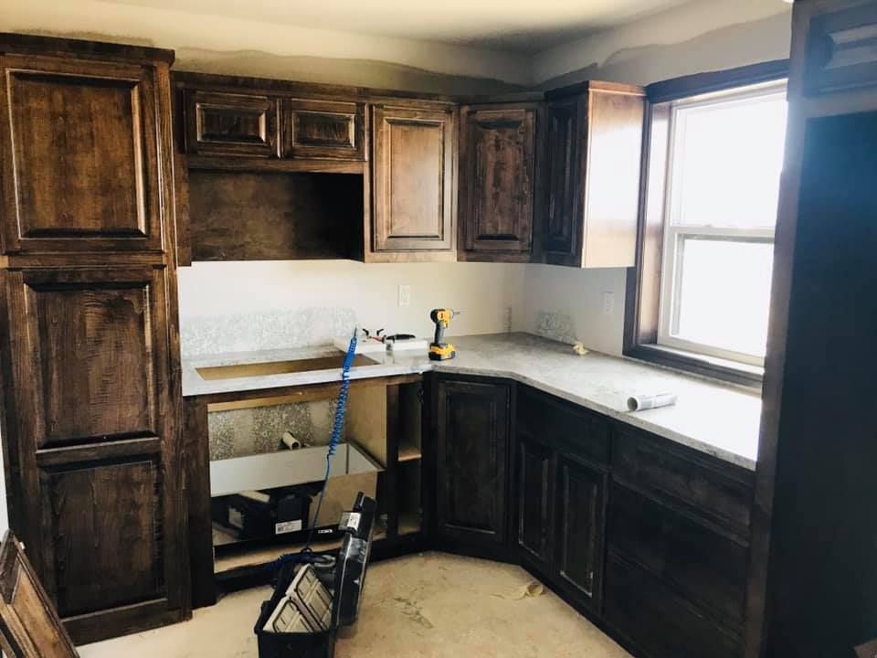 A kitchen with wooden cabinets and granite counter tops is being remodeled.