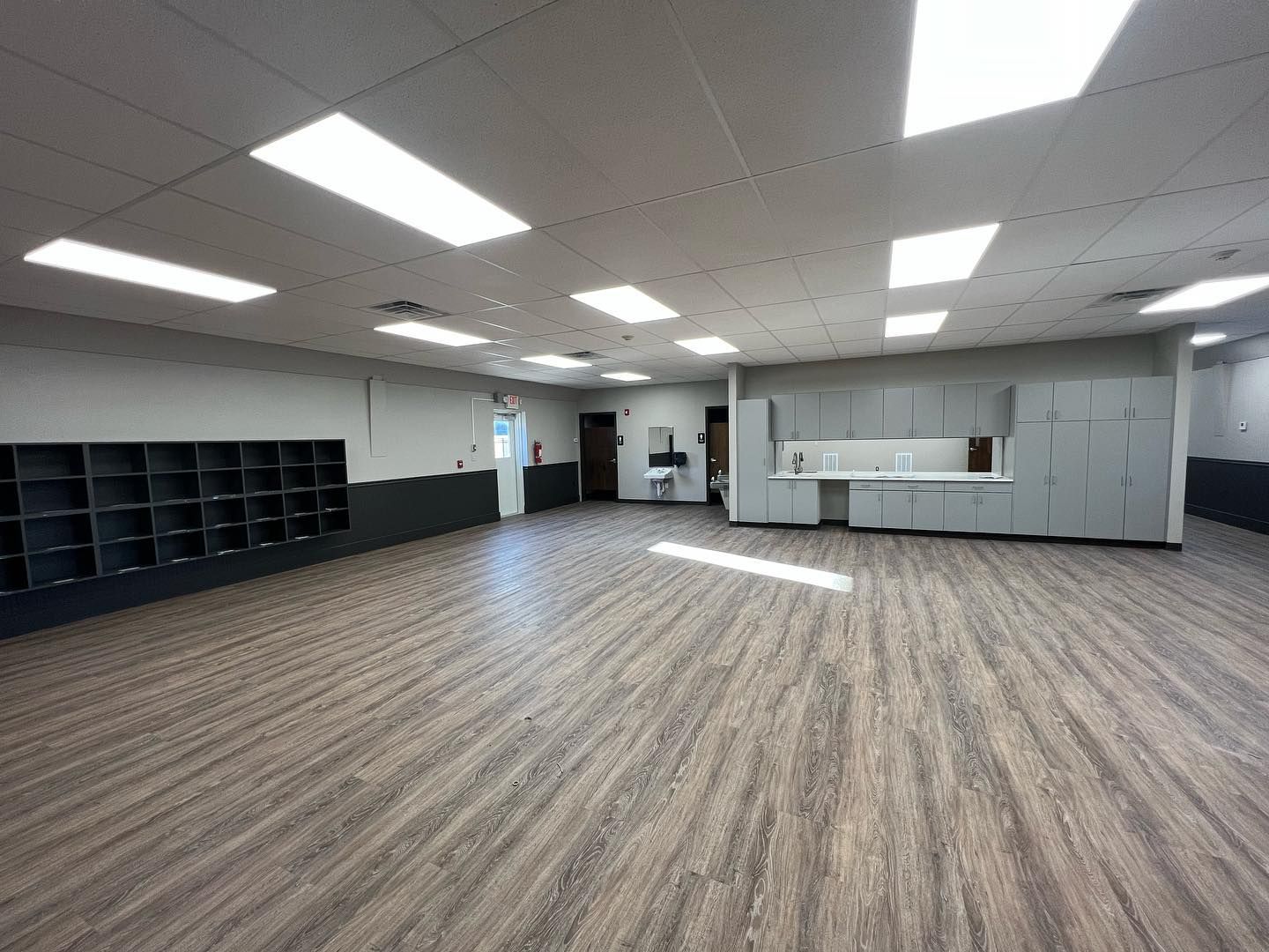 A large empty room with wooden floors and cabinets.