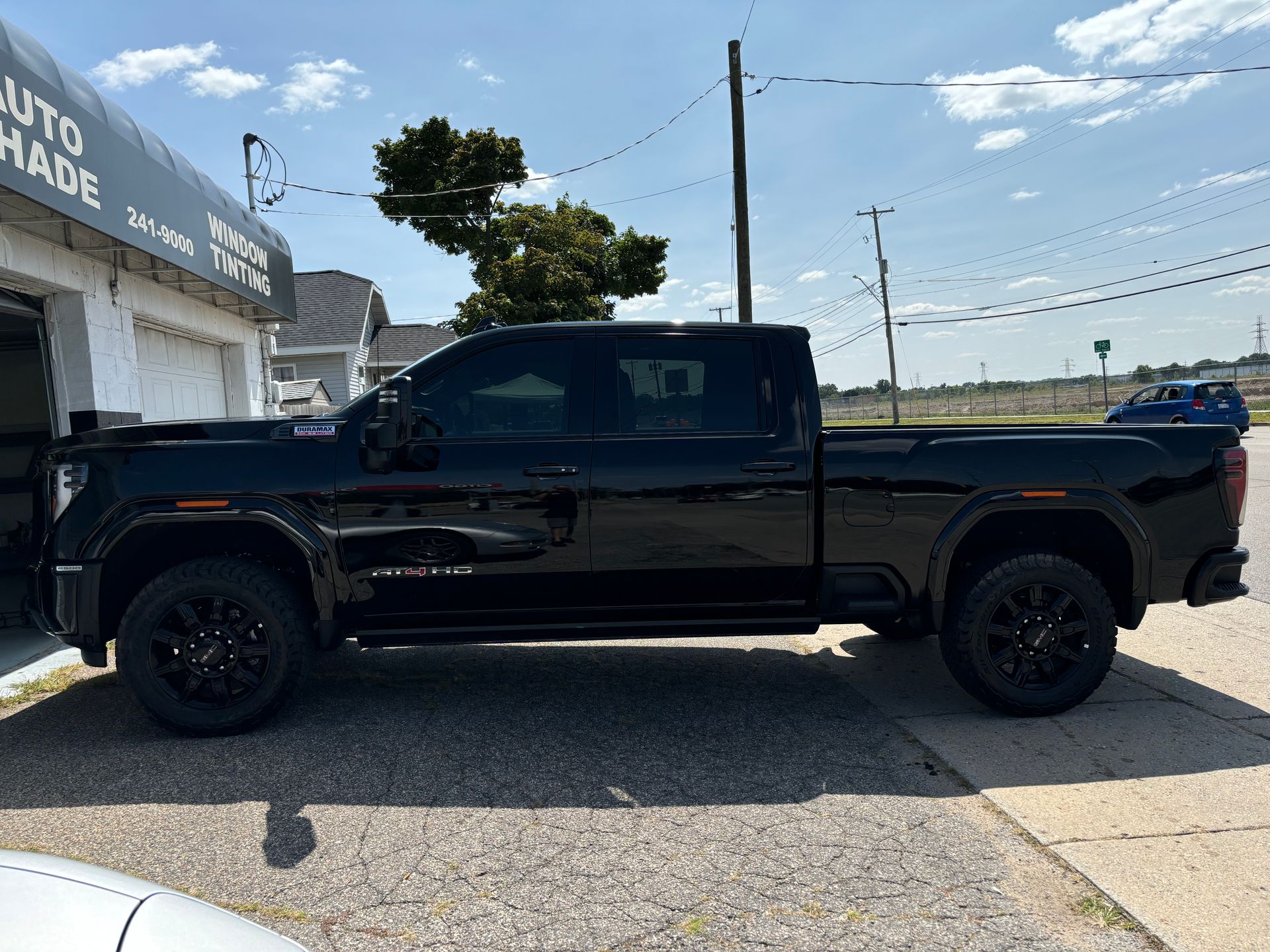 A black truck is parked in front of a garage.