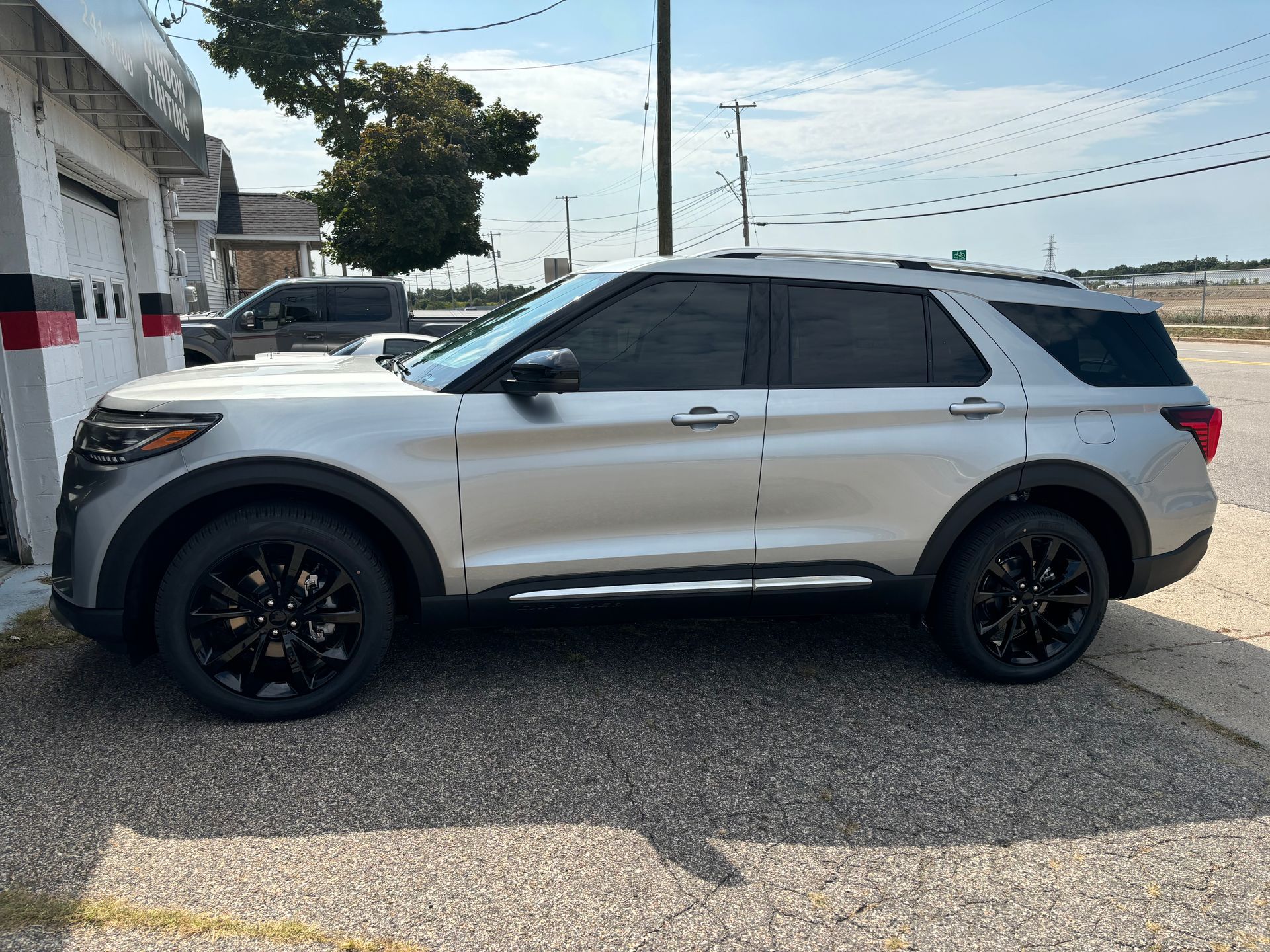 A silver ford explorer is parked in a parking lot.
