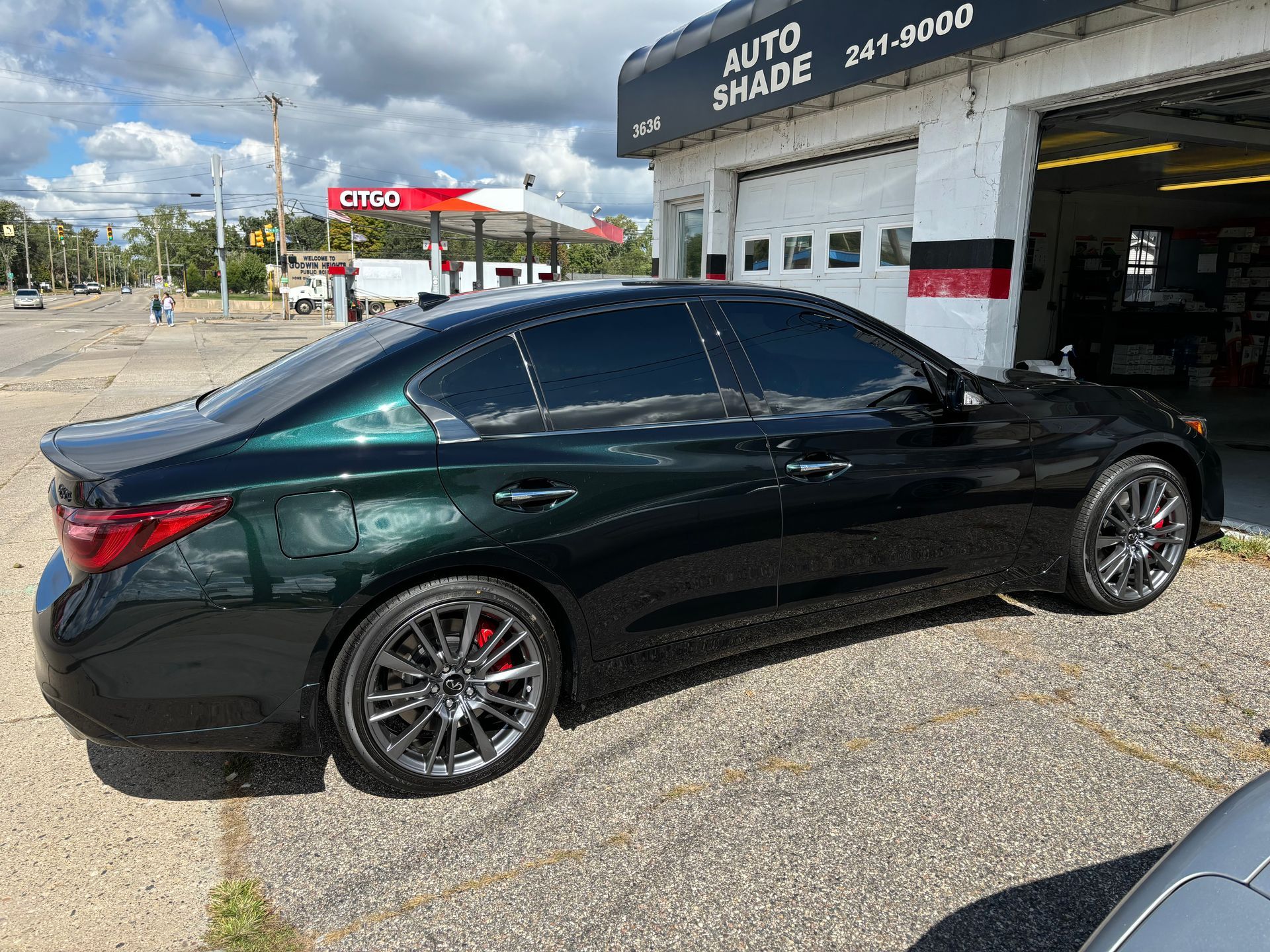 A black car is parked in front of a garage.