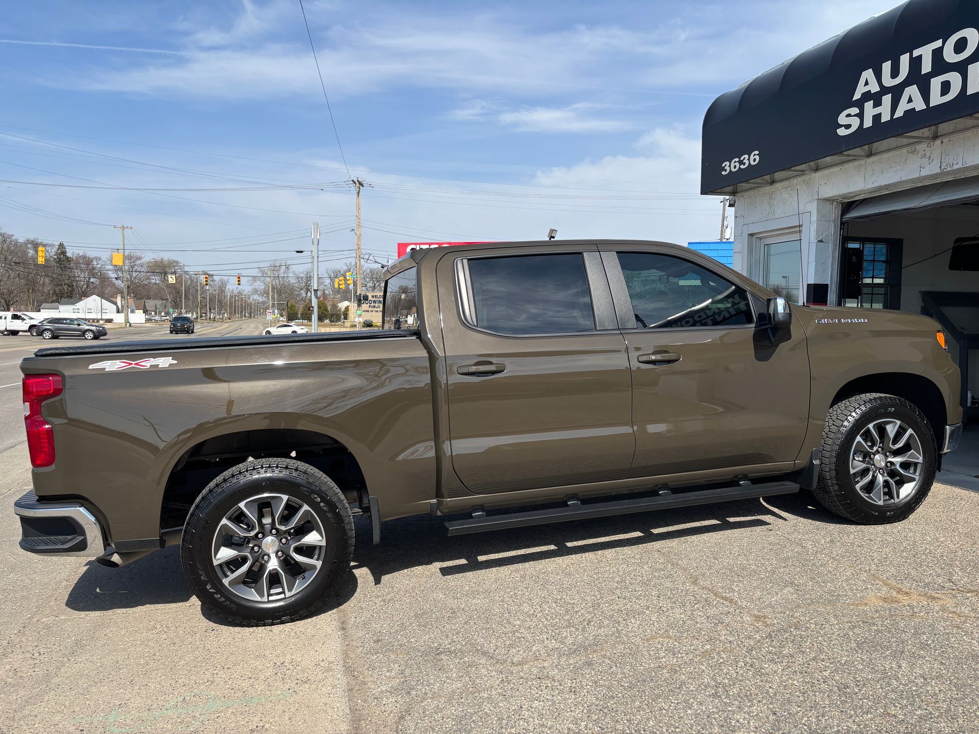 A brown truck is parked in front of a garage.