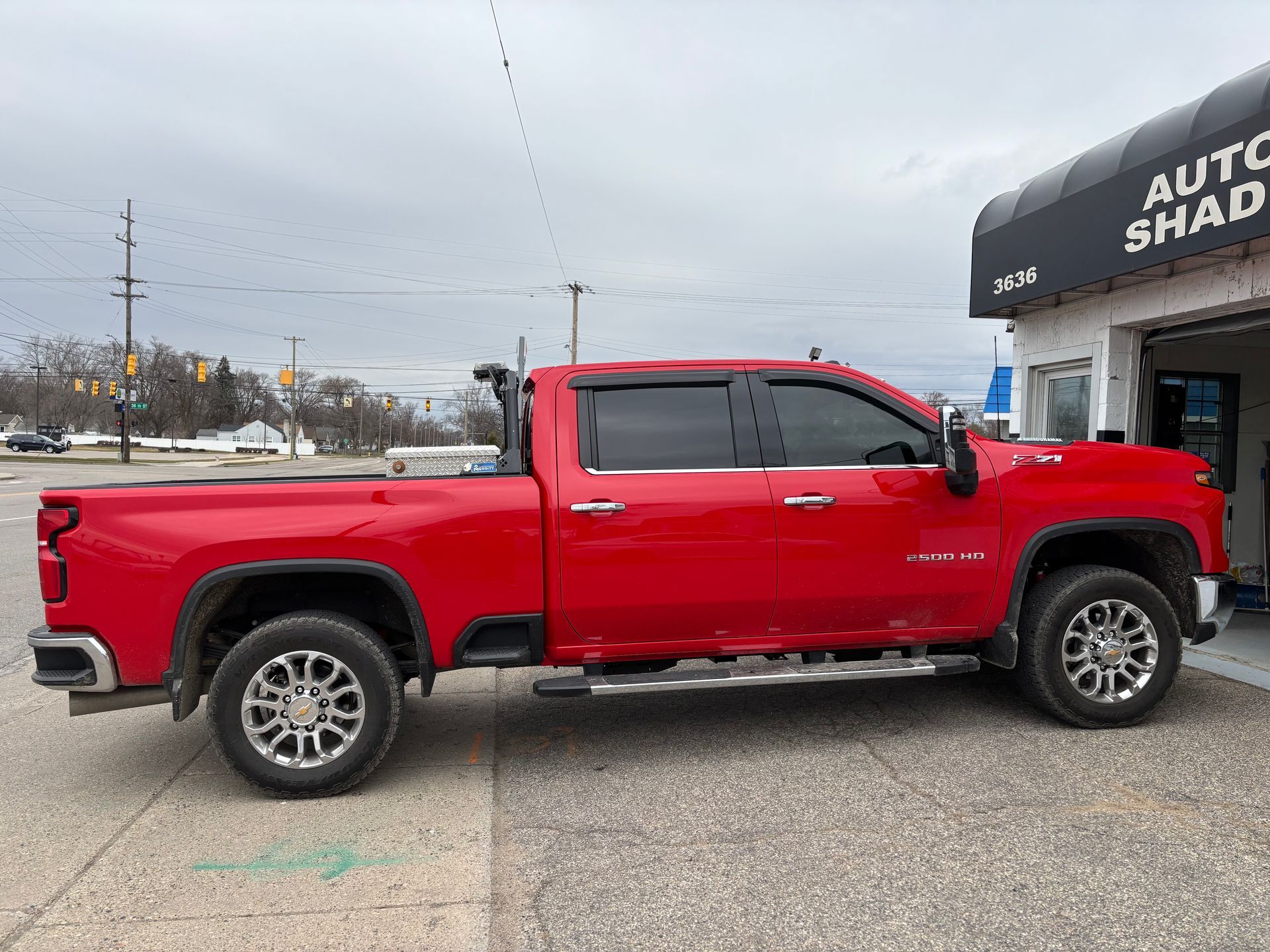 A red truck is parked in front of a car wash.