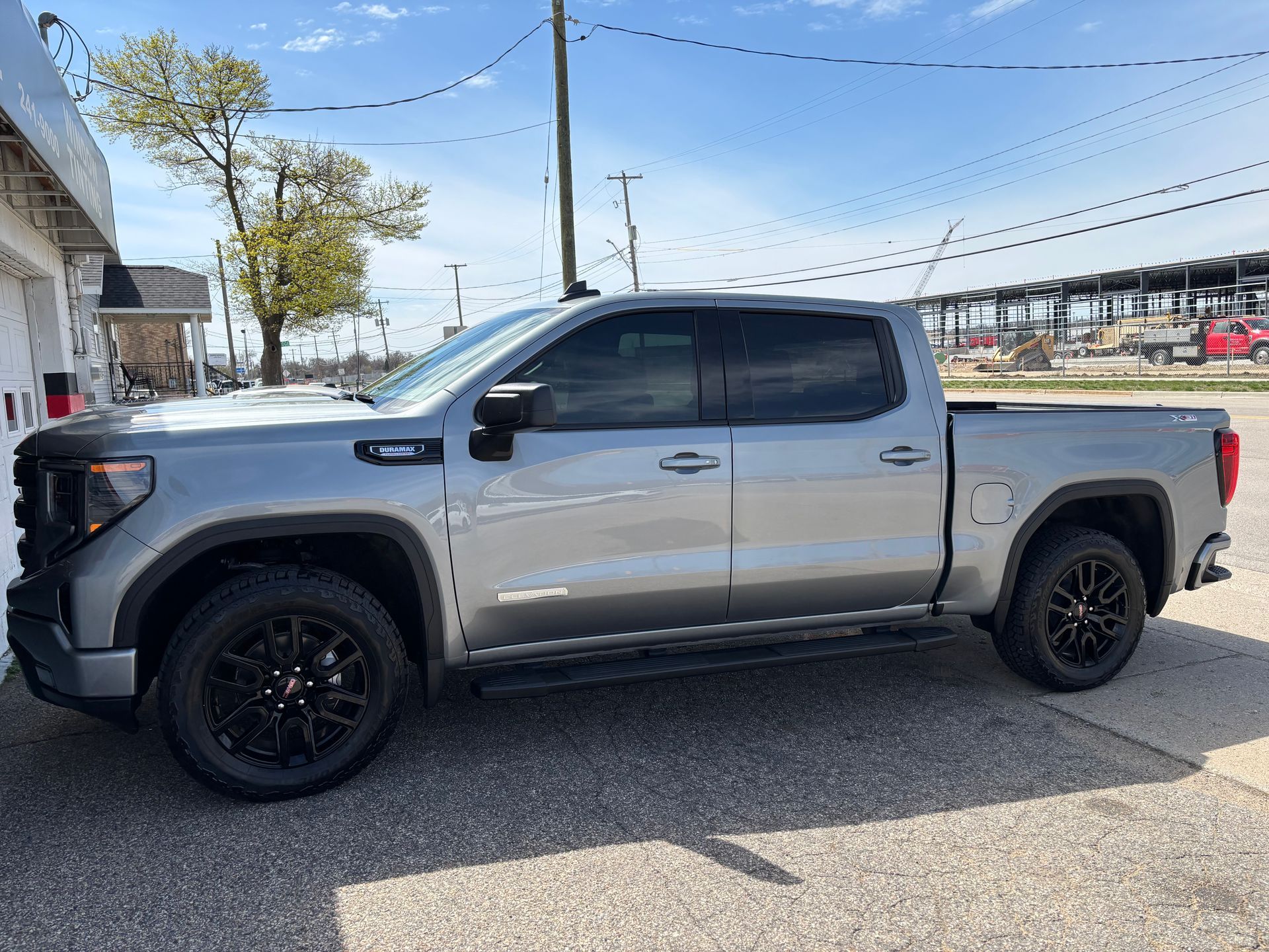 A silver pickup truck is parked on the side of the road.