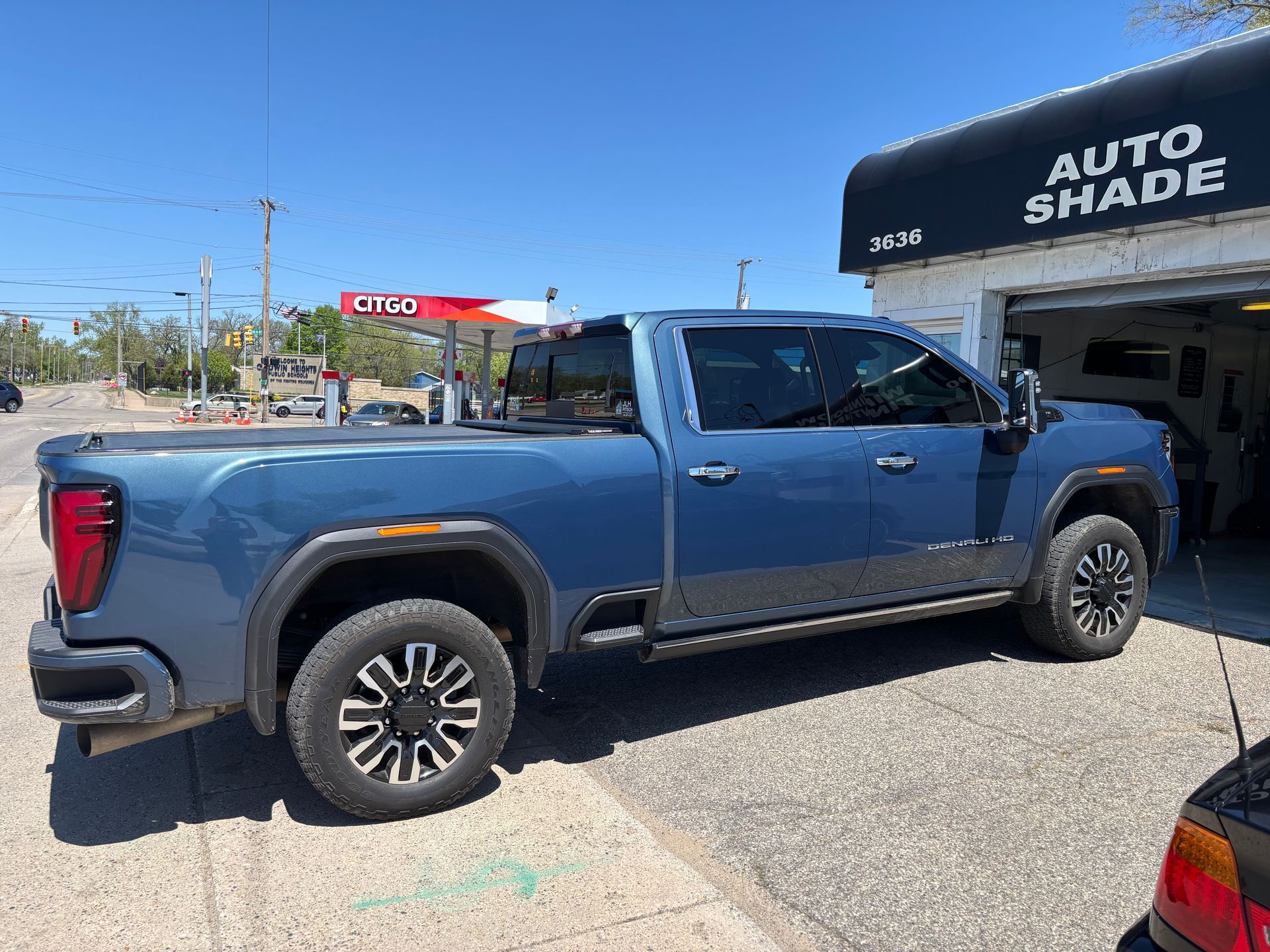 A blue truck is parked in front of a garage.