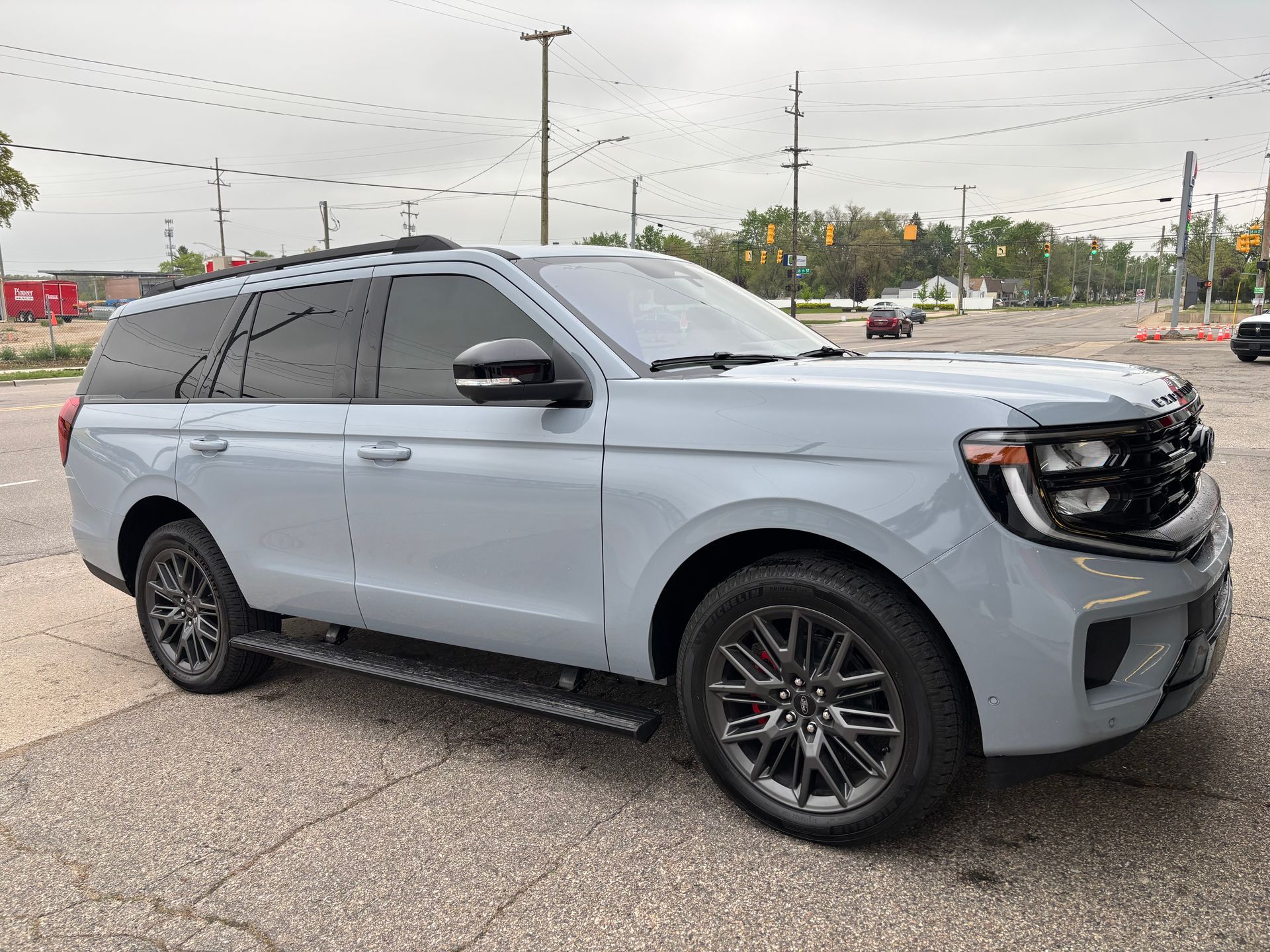 A gray ford expedition is parked in a parking lot.